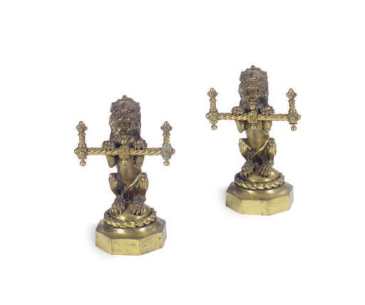 A PAIR OF POLISHED BRASS LION FORM ANDIRONS,