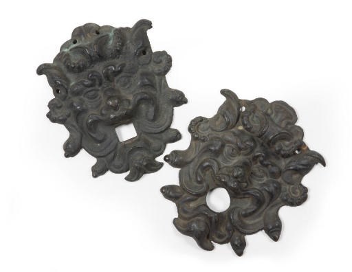 A MATCHED PAIR OF BRONZE BACKPLATES SHAPED AS GROTESQUE MASKS