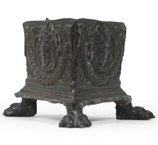 A TRIANGULAR BRONZE INKWELL