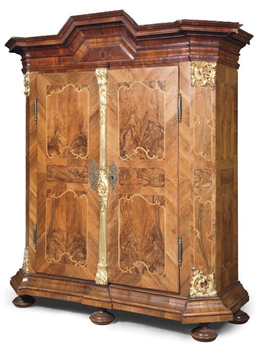 AN AUSTRIAN PARCEL-GILT WALNUT, FIGURED-WALNUT AND FRUITWOOD CUPBOARD