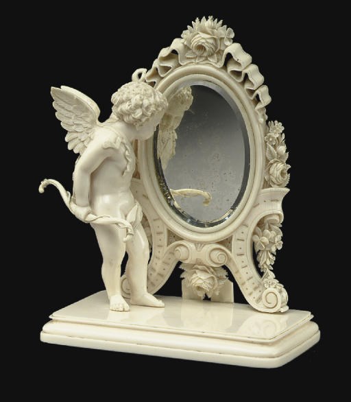 A FRENCH IVORY FIGURE OF A CUPID AT A MIRROR**