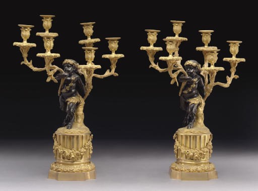 A PAIR OF FRENCH PATINATED AND PARCEL-GILT BRONZE SIX-LIGHT FIGURAL CANDELABRA