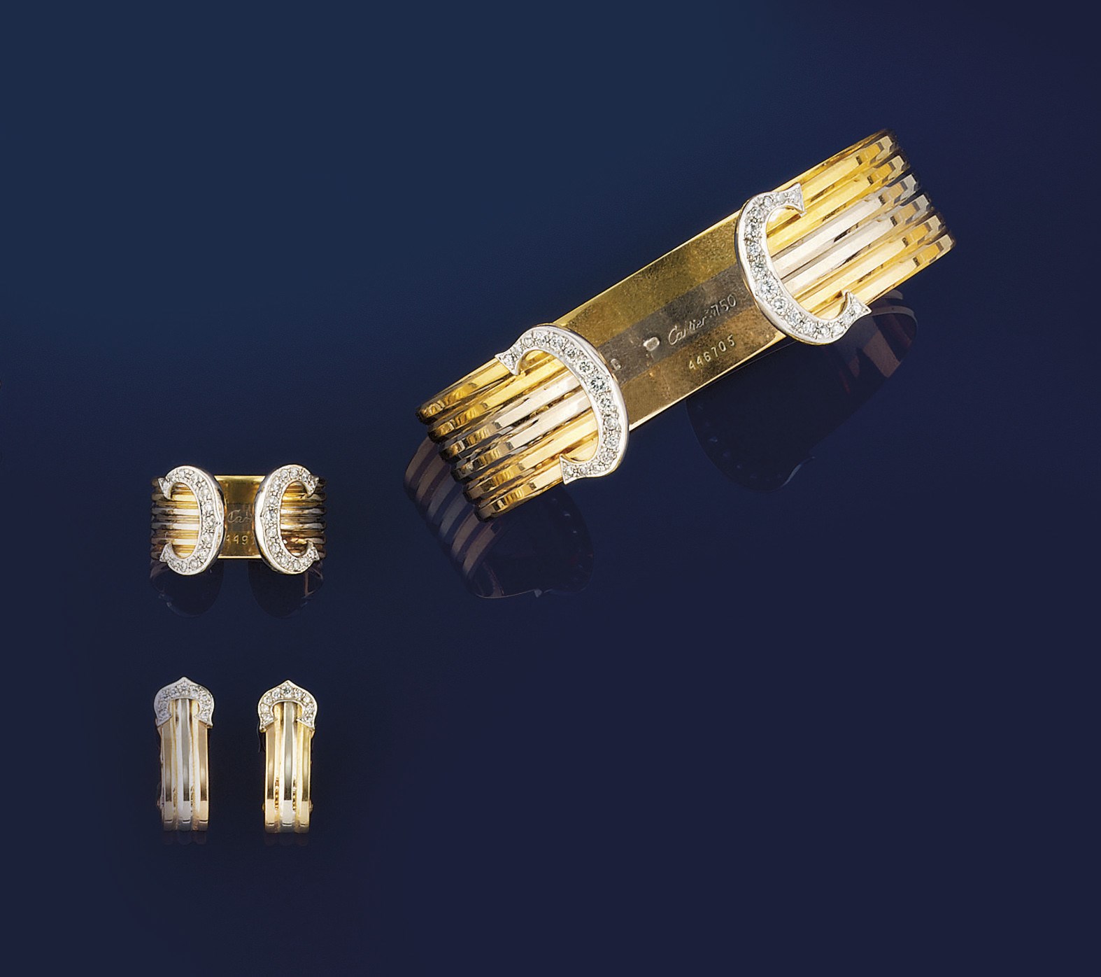 A gold and diamond bangle, ring and pair of earclips, by Cartier