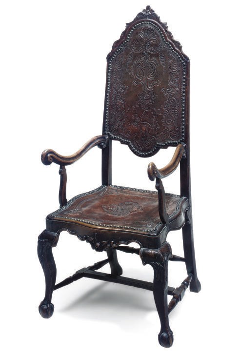 AN IBERIAN EMBOSSED LEATHER, WALNUT AND ELM OPEN ARMCHAIR