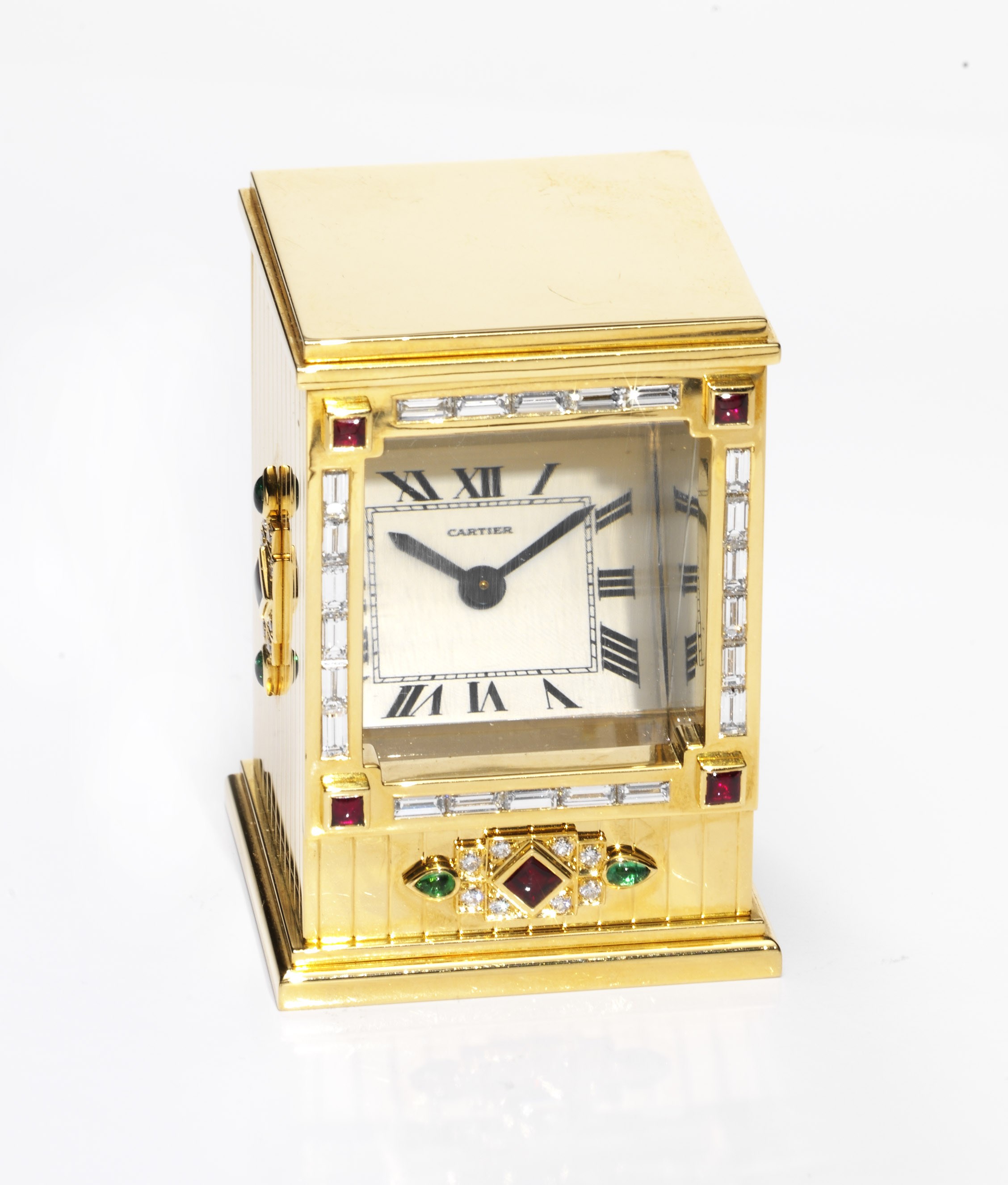 CARTIER
VERY FINE AND RARE, 18K GOLD, DIAMOND, EMERALD AND RUBY-SET RECTANGULAR PRISM CLOCK