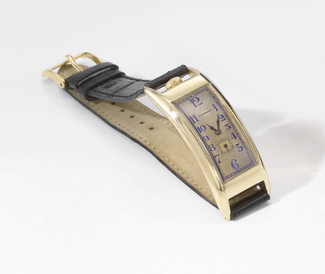 Movado. An unusual, large and early 18K gold rectangular curved hinged wristwatch