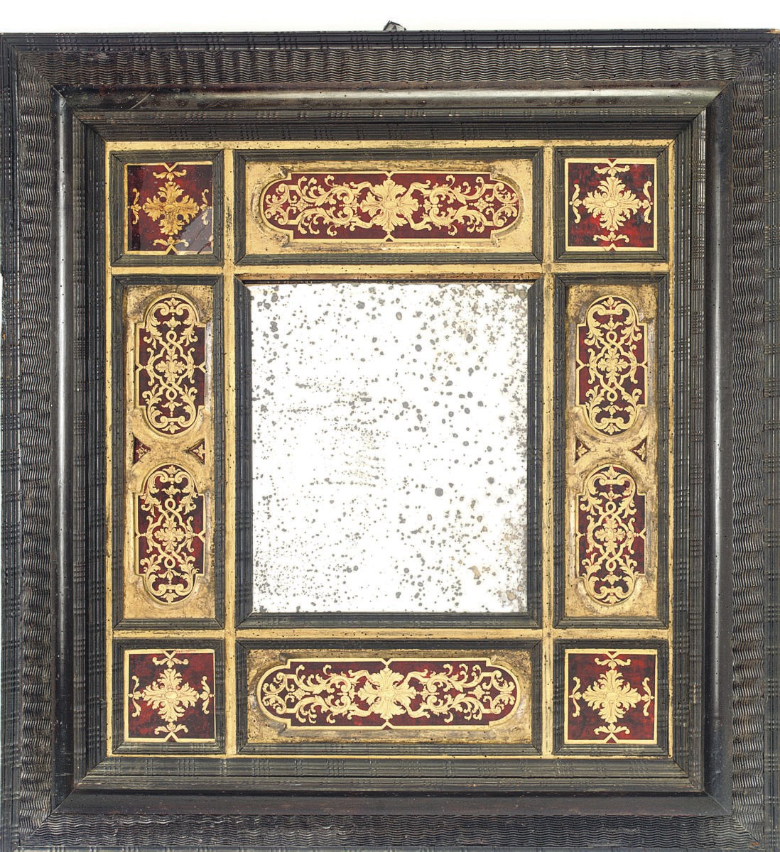 AN ITALIAN OR FLEMISH EBONISED PARCEL GILT AND VERRE ÉGLOMISÉ MIRROR