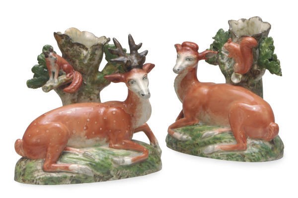 A PAIR OF STAFFORDSHIRE PEARLWARE SPILL VASES MODELED AS STAG OR HIND ATTENDED BY A SQUIRREL,