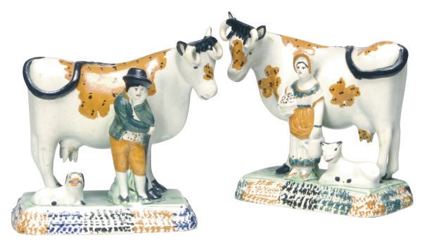 A PAIR OF STAFFORDSHIRE PEARLWARE FIGURE GROUPS OF A FARMER OR COMPANION STANDING BEFORE A COW,