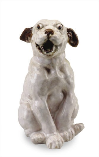 A FRENCH WHITE AND BROWN TIN-GLAZED TERRACOTTA MODEL OF PUPPY,