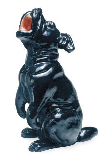 A FRENCH BLACK TIN-GLAZED TERRACOTTA MODEL OF A DOG,