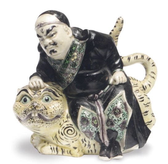 A CHINESE PORCELAIN FAMILLE NOIRE MODEL OF AN IMMORTAL ATOP A TIGER,
