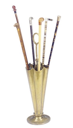 A BRASS UMBRELLA STAND AND GROUP OF WALKING STICKS**,