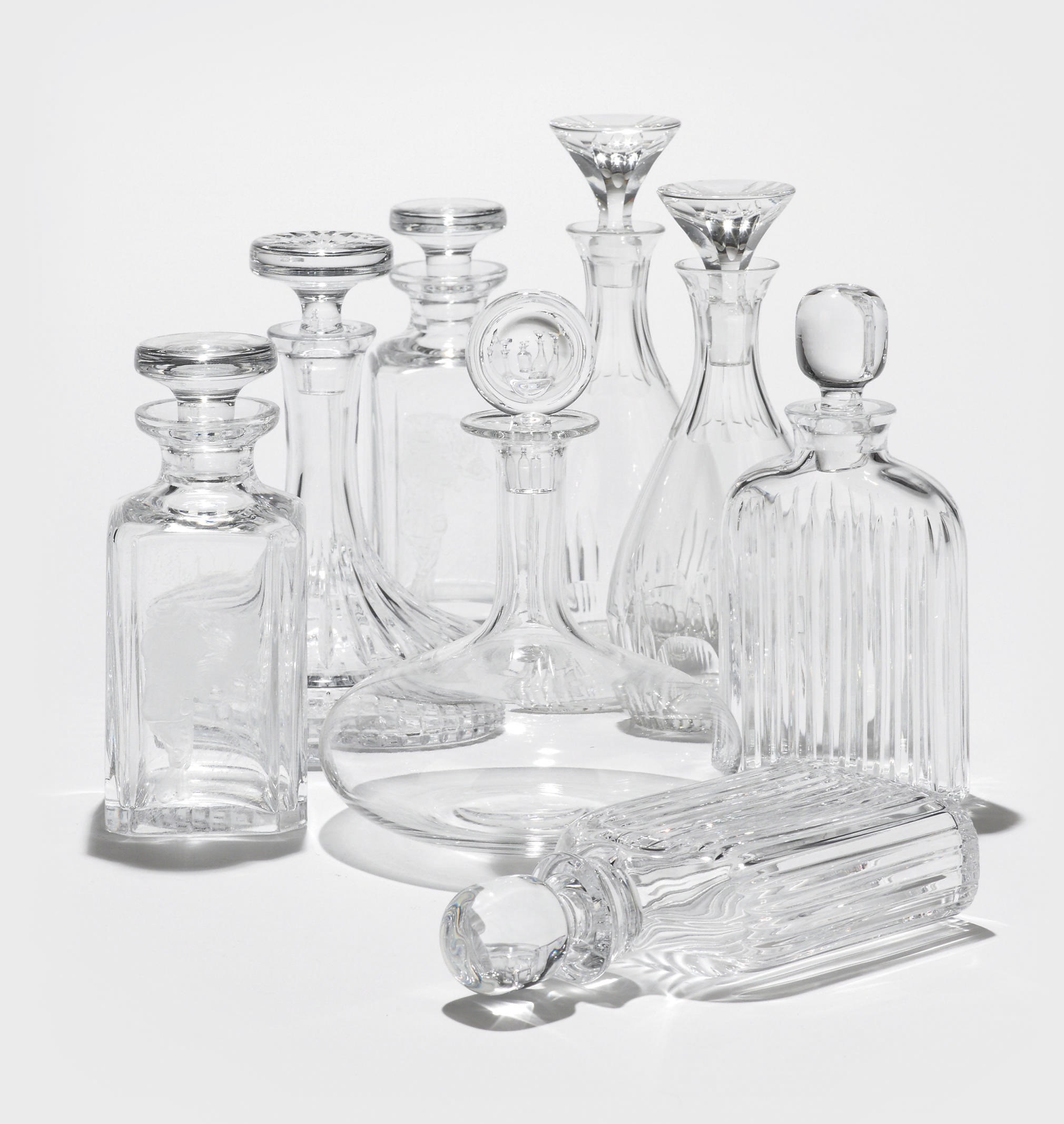 EIGHT CLEAR GLASS DECANTERS AND STOPPERS