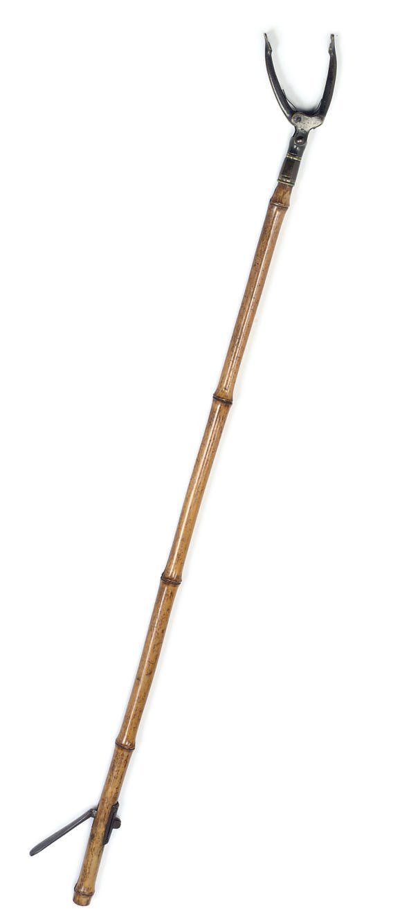A REGENCY METAL-MOUNTED SIMULATED BAMBOO BOOK-GRASP