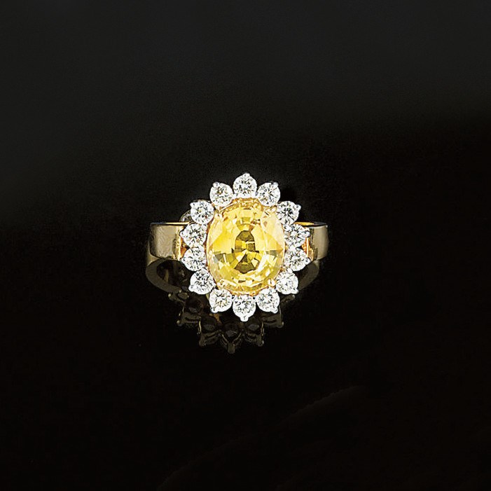A yellow sapphire and diamond cluster ring