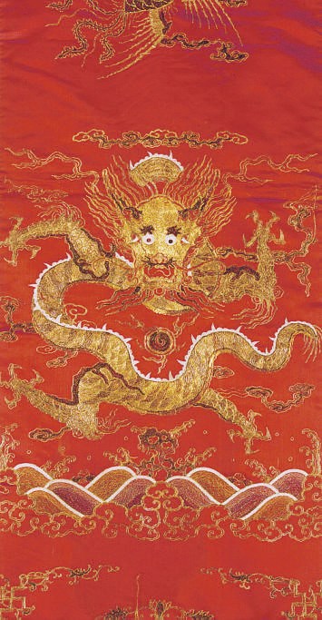 A CHINESE EMBROIDERED SILK RED GROUND AND METALLIC THREAD CHAIR COVER,