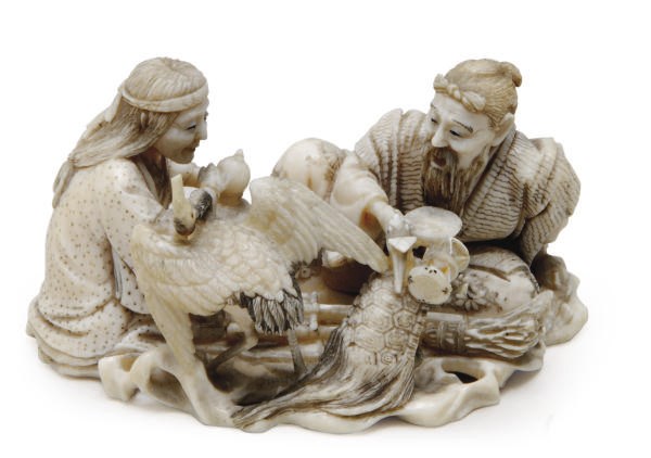 A JAPANESE IVORY NETSUKE OF JO AND UBA WITH A CRANE AND A TURTLE,**