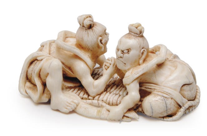 A JAPANESE IVORY MODEL OF TWO NIO ARM-WRESTLING ON A SANDAL,**