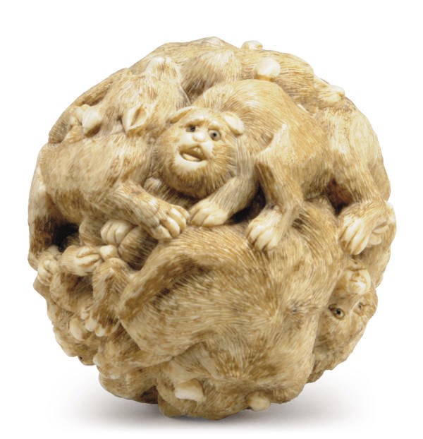 A JAPANESE IVORY TABLE ORNAMENT CARVED WITH FIGURES OF DOGS,**