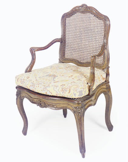 A LOUIS XV WALNUT AND CANED FAUTEUIL,