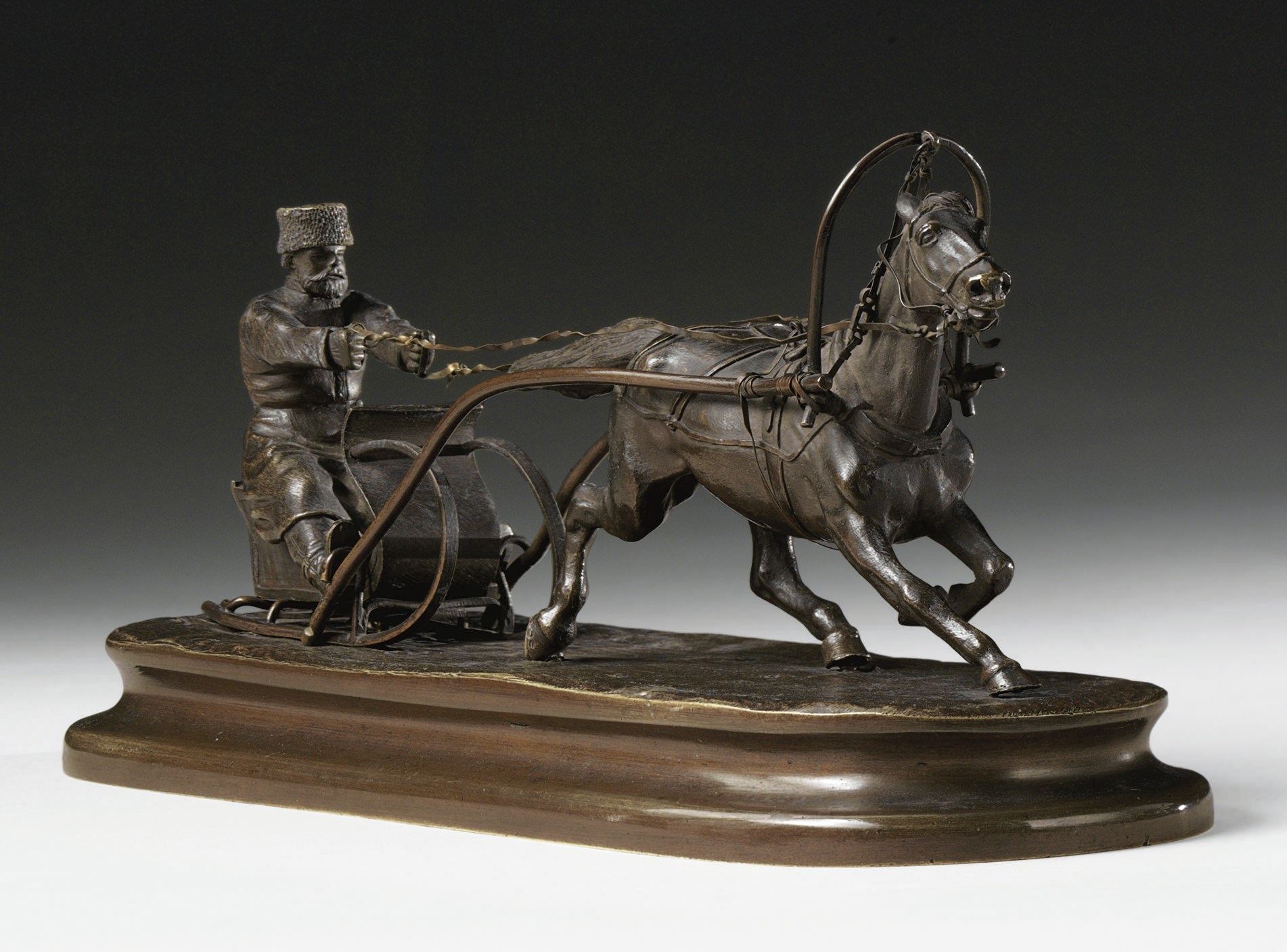 A bronze group of a horse passing a peasant sleigh