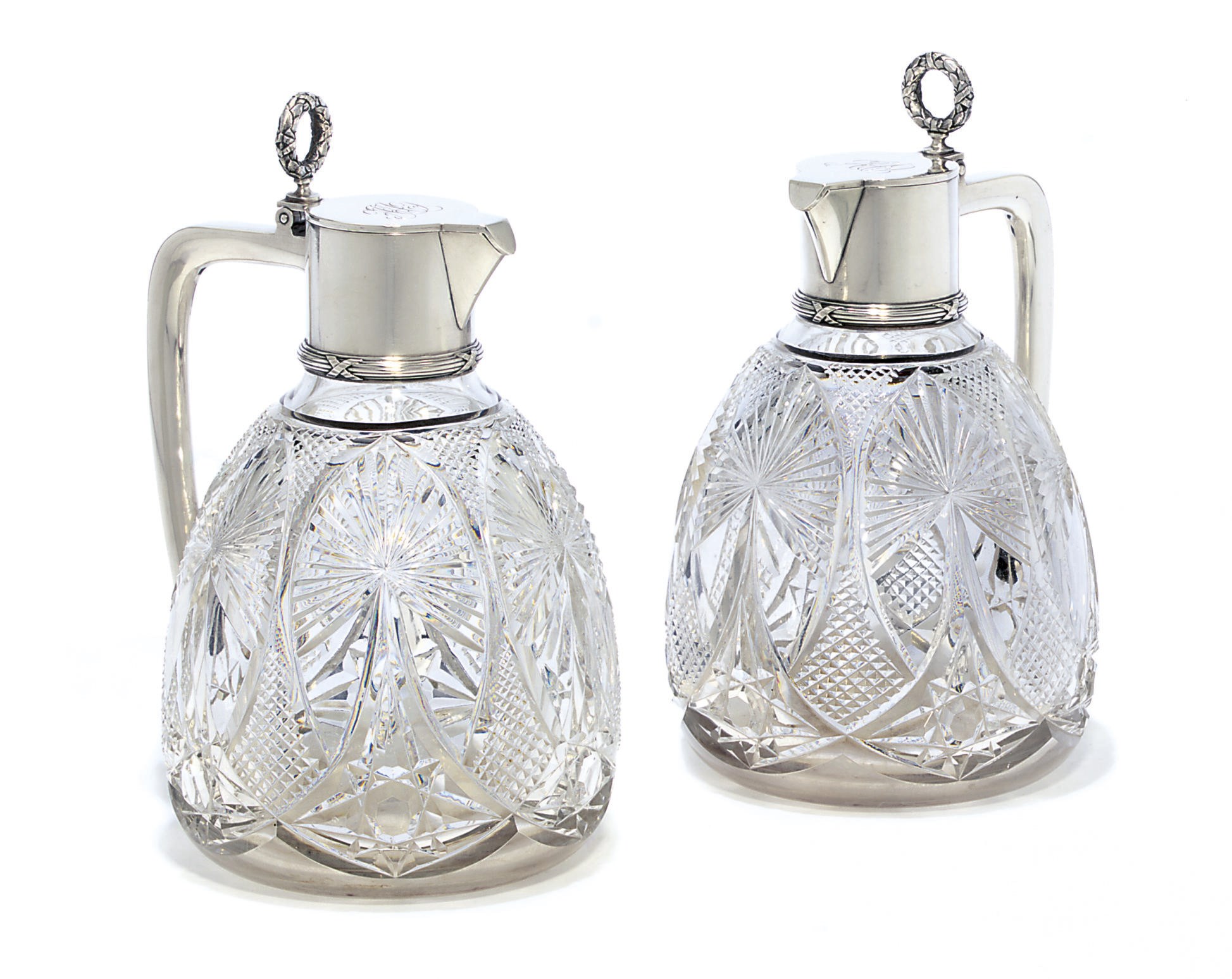 A pair of silver-mounted cut-glass wine jugs