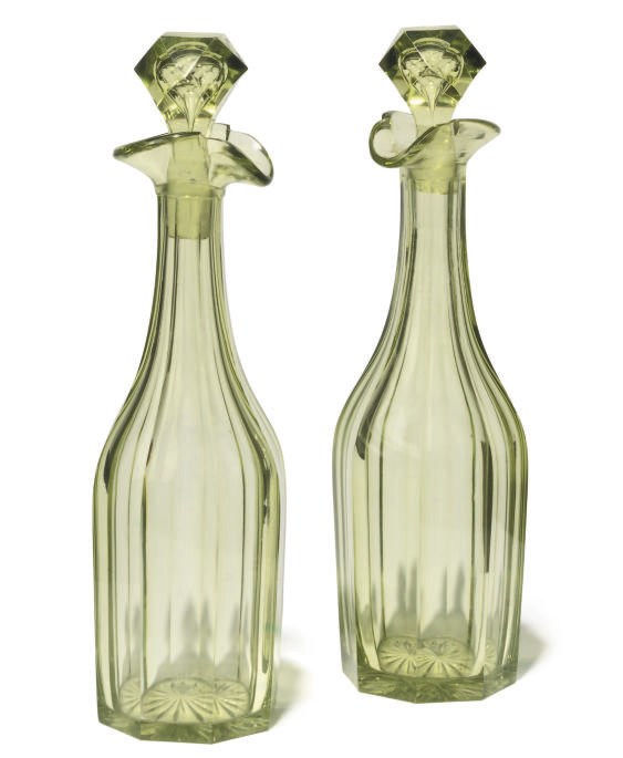 A PAIR OF ENGLISH GREEN-TINTED GLASS DECANTERS AND STOPPERS