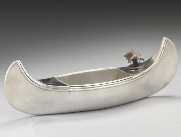 AN EDWARDIAN SILVER NOVELTY SPIRIT LIGHTER MODELLED AS A CANOE