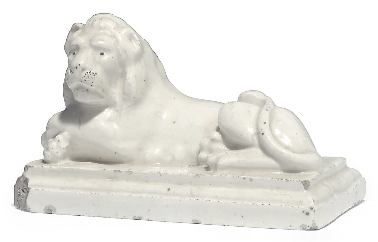 A CONTINENTAL WHITE PORCELAIN MODEL OF A RECUMBENT LION