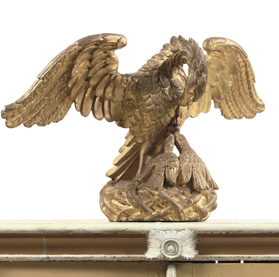 A CARVED GILTWOOD SCULPTURE OF AN EAGLE FEEDING HIS CHICKS ALLEGORICAL OF CHARITY