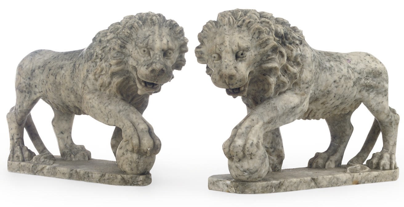 A PAIR OF CARVED ALABASTER MODELS OF PACING LIONS