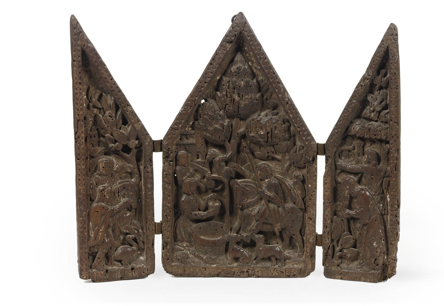 A CARVED WOOD RELIEF TRYPTYCH DEPICTING HUNTSMEN BY A WELL
