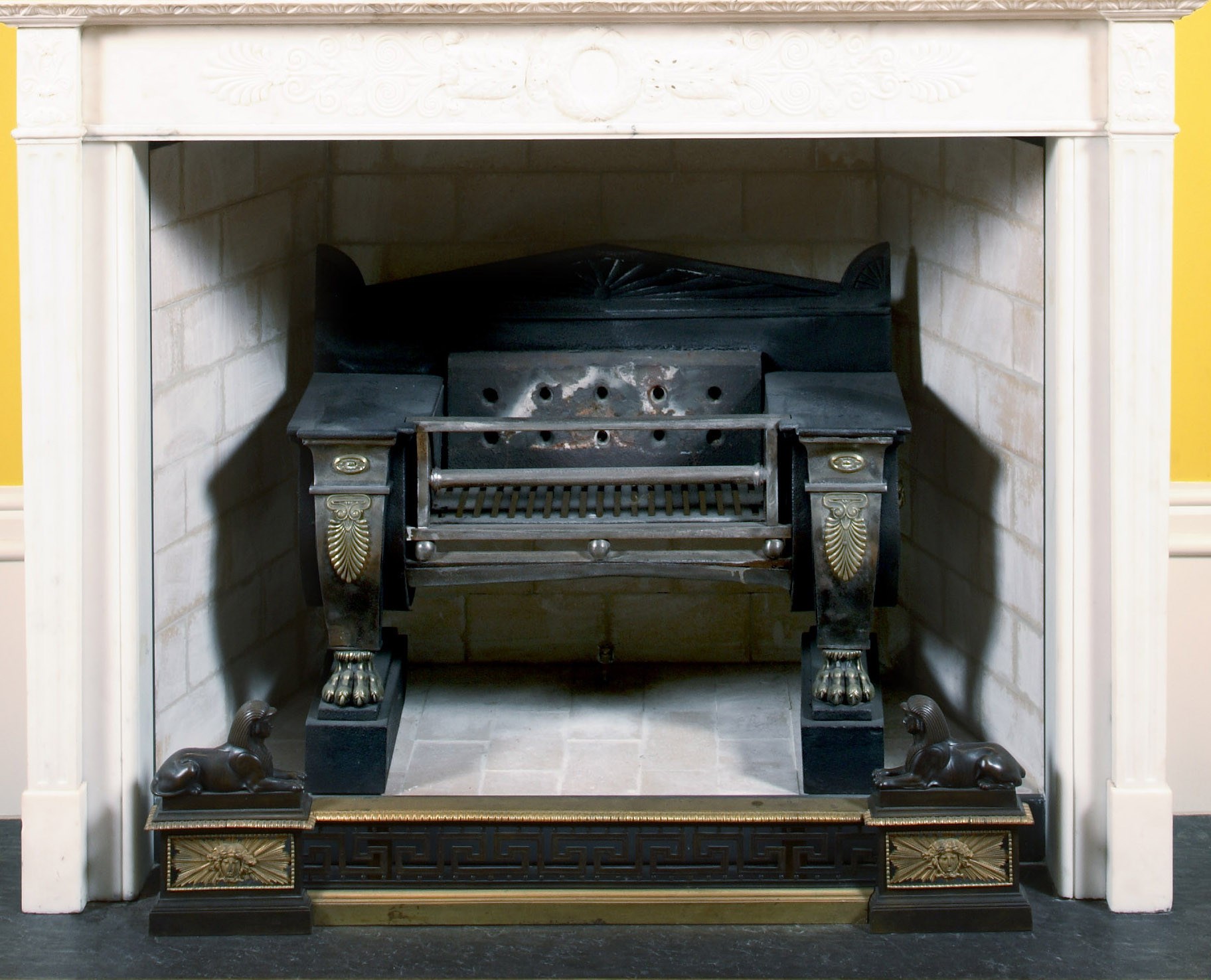 A REGENCY BRASS-MOUNTED CAST-IRON FIREGRATE