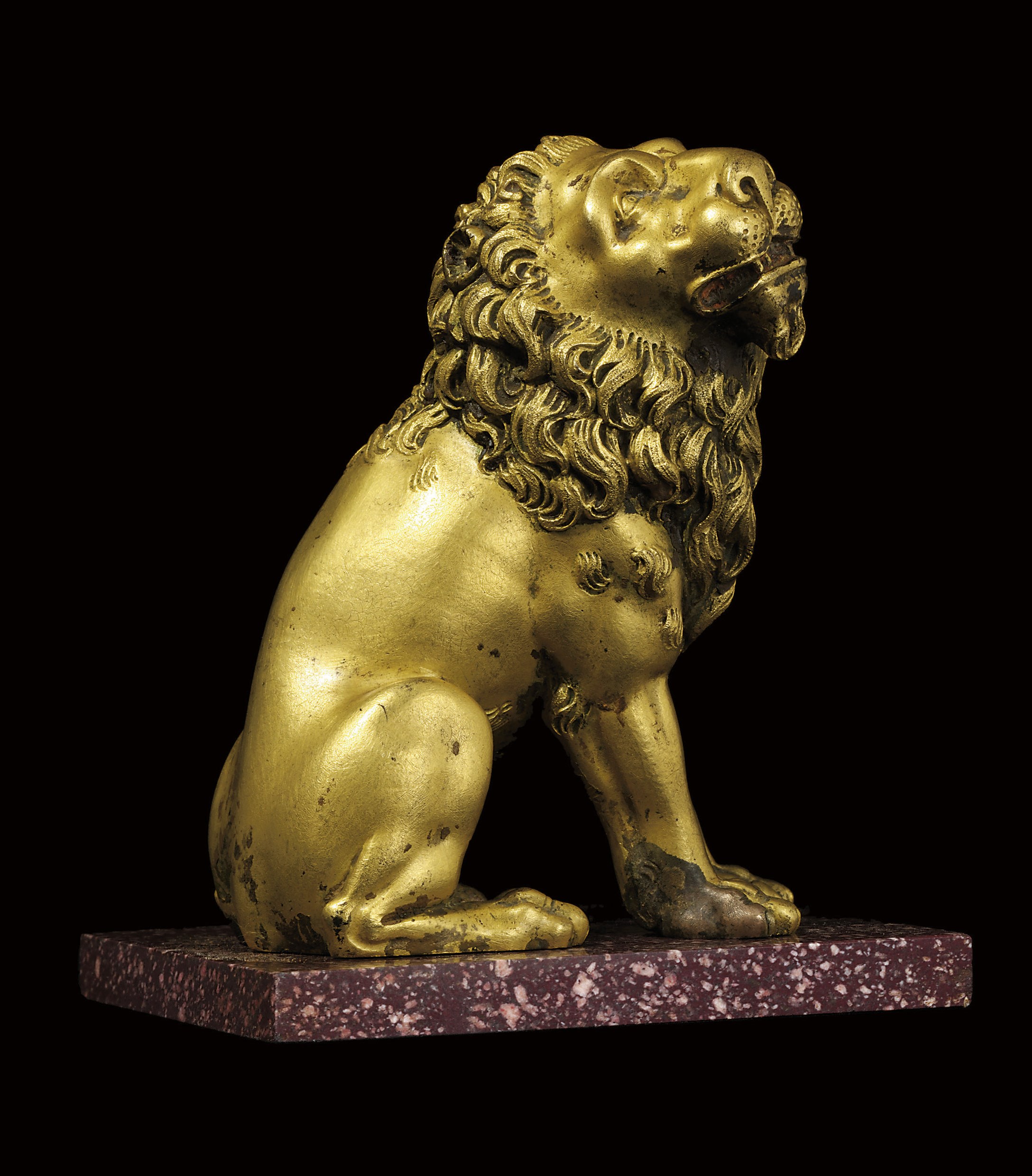 A GILT-BRONZE MODEL OF A SEATED LION