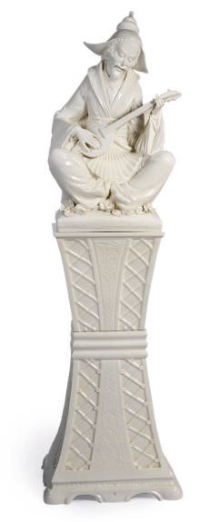 A CONTINENTAL BLANC DE CHINE CHINOISERIE FIGURE ON A TWO PART PEDESTAL,