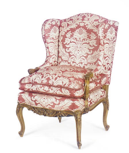 A FRENCH BEECHWOOD AND UPHOLSTERED WINGBACK FAUTEUIL,