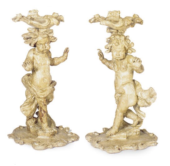 A CONTINENTAL PAIR OF PINE TORCHERES WITH FIGURAL YOUTH SUPPORTS,