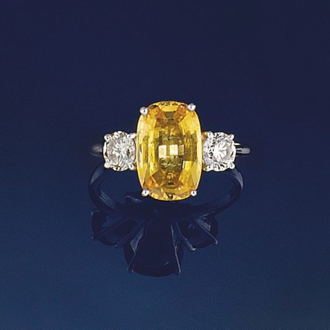 A yellow sapphire and diamond three stone ring