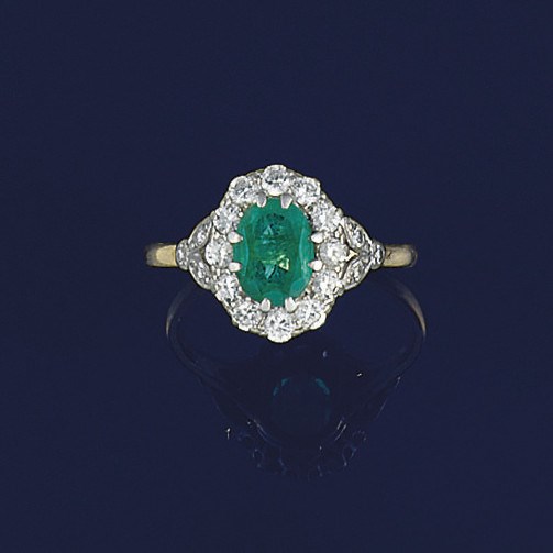 An emerald and diamond cluster ring