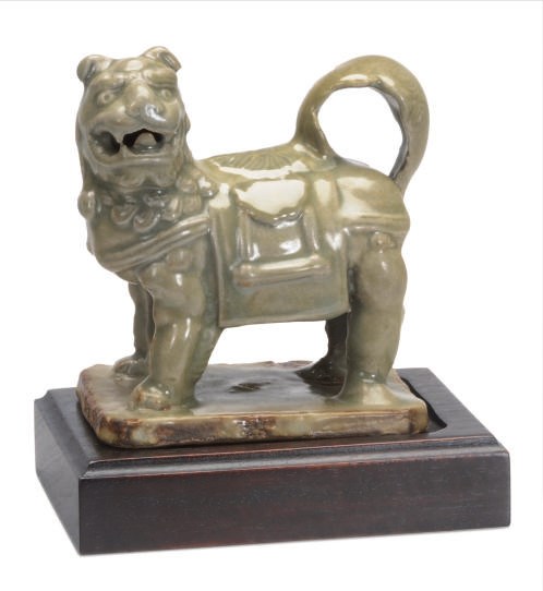 A CELADON GLAZED MODEL OF A STANDING LION,