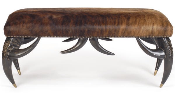 AN EBONIZED AND COWHIDE UPHOLSTERED BENCH,