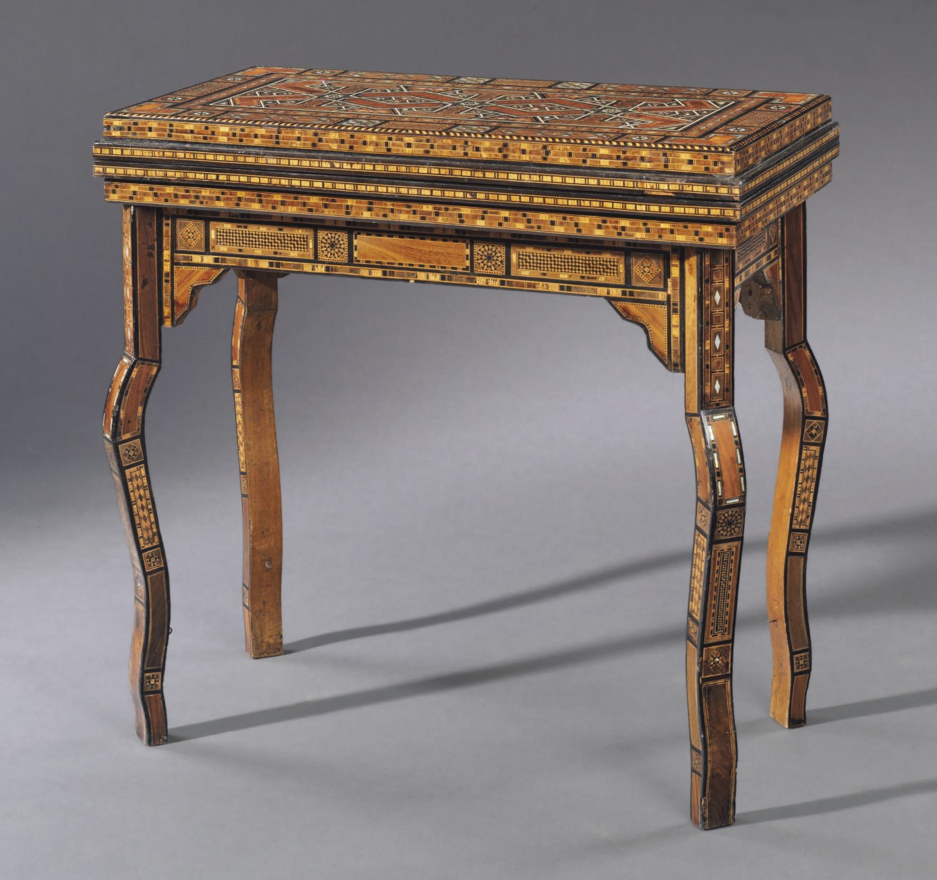 A MIDDLE EASTERN IVORY, BONE, MOTHER-OF-PEARL, EBONY, HARDWOOD AND PARQUETRY GAMES TABLE**