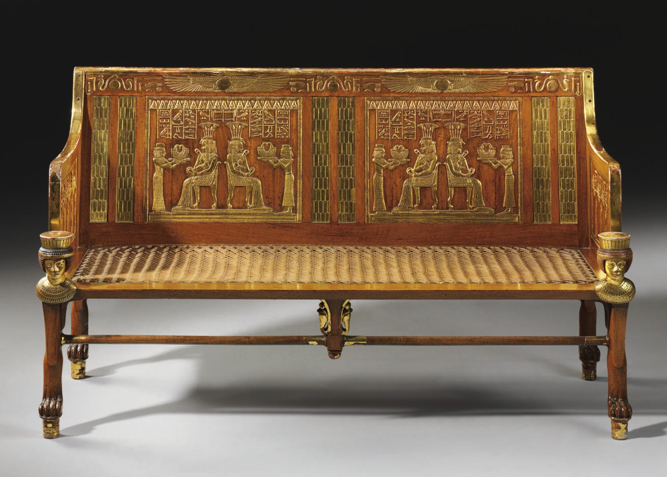 AN EGYPTIAN REVIVAL MAHOGANY AND PARCEL-GILT SETTEE