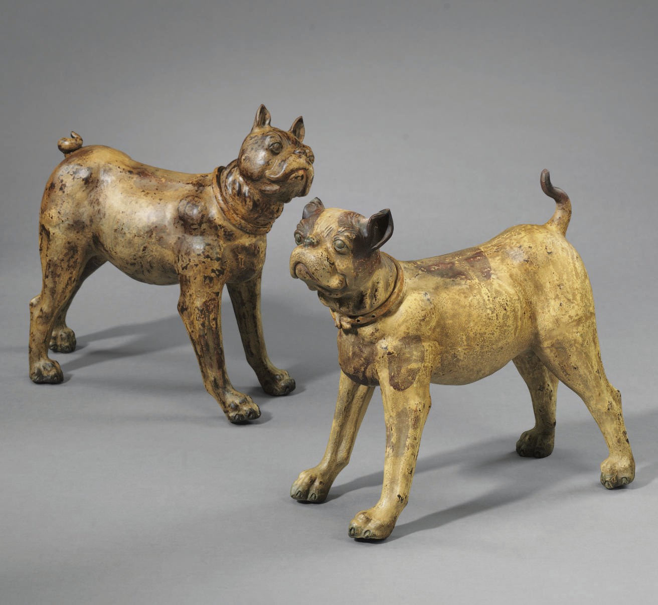 A PAIR OF POLYCHROME-DECORATED COMPOSITION FIGURES OF DOGS