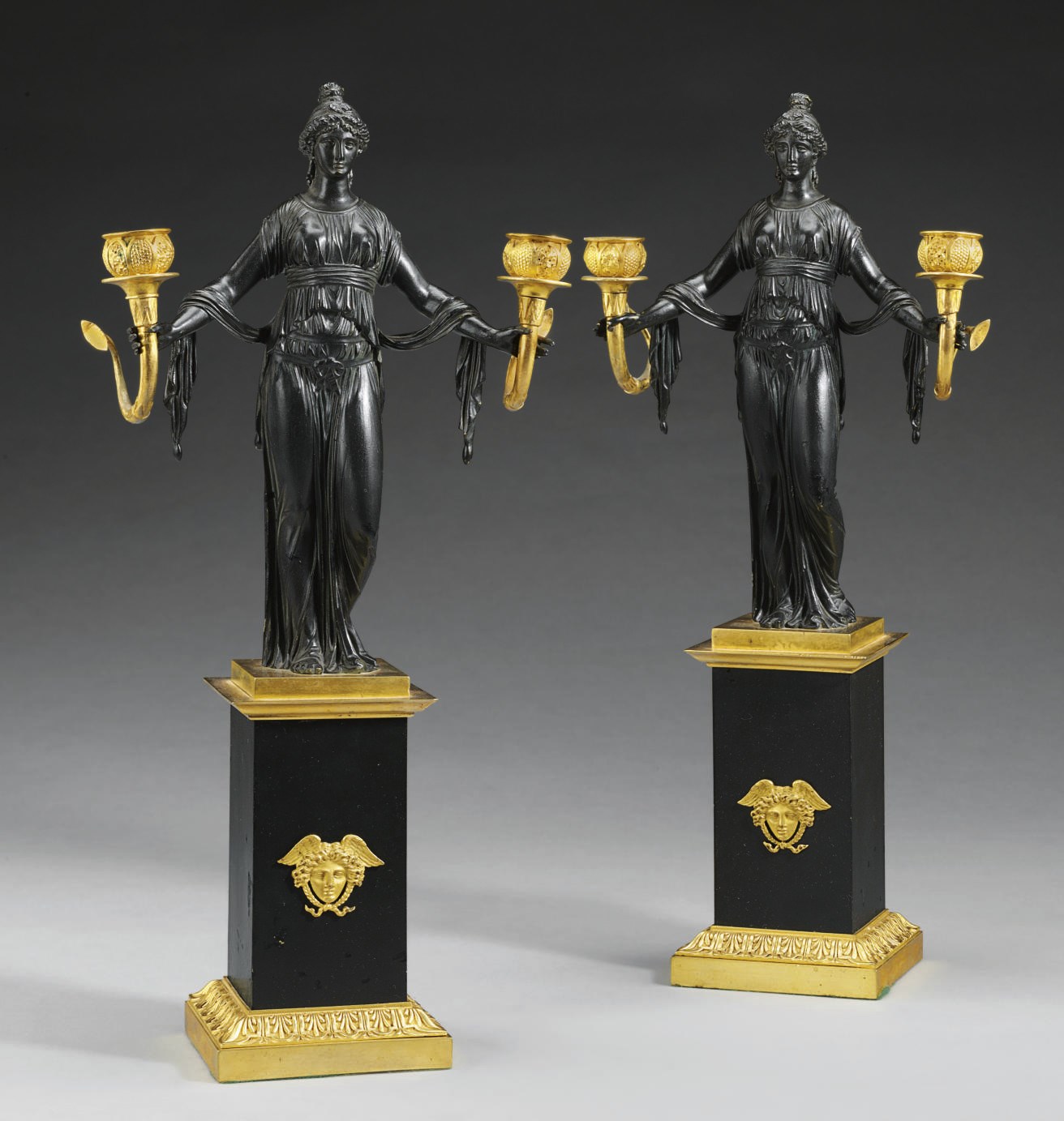 A PAIR OF NORTH EUROPEAN PATINATED-BRONZE AND ORMOLU TWIN-BRANCH CANDELABRA