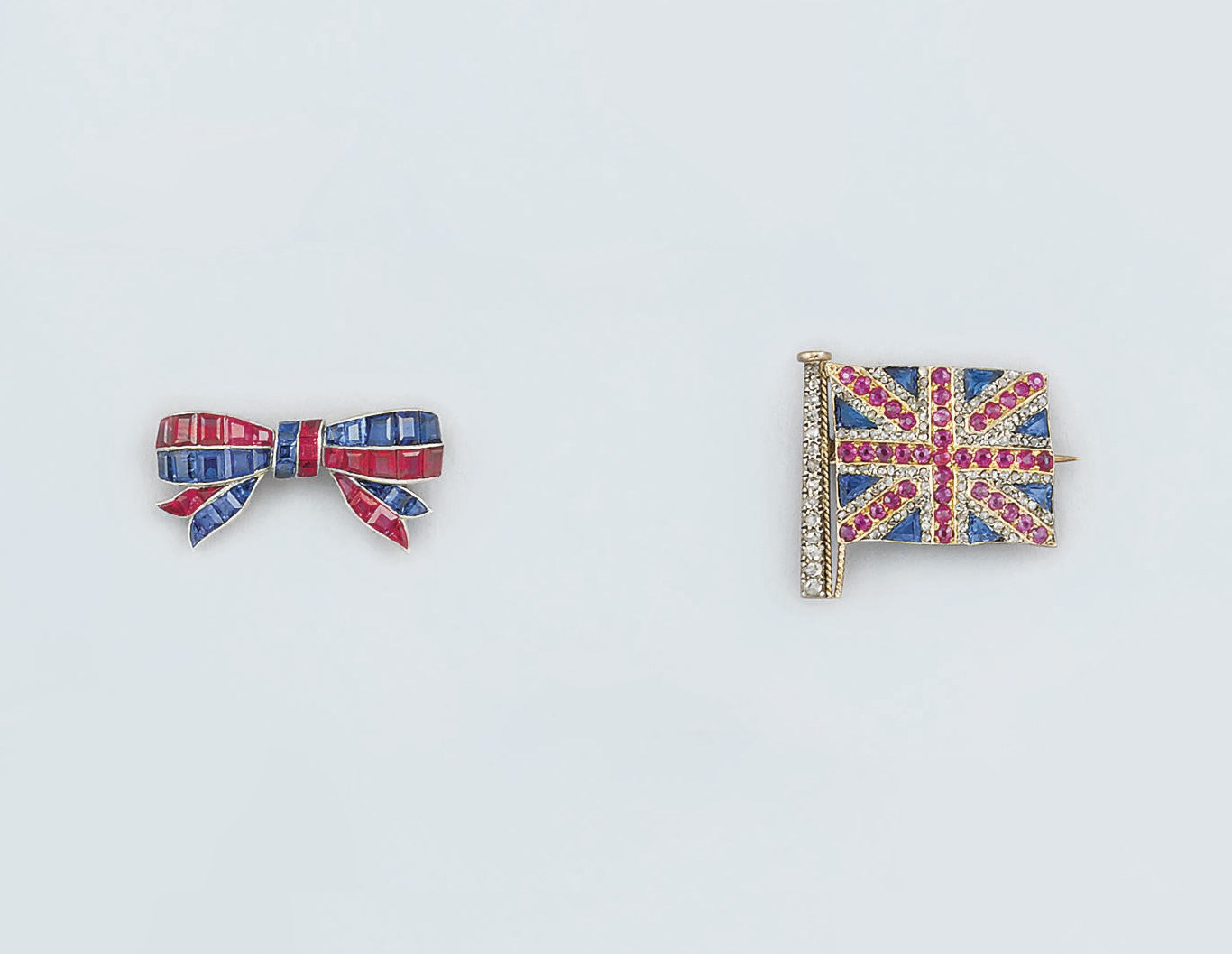 A diamond and gem Union Jack brooch and a ruby and sapphire bow brooch