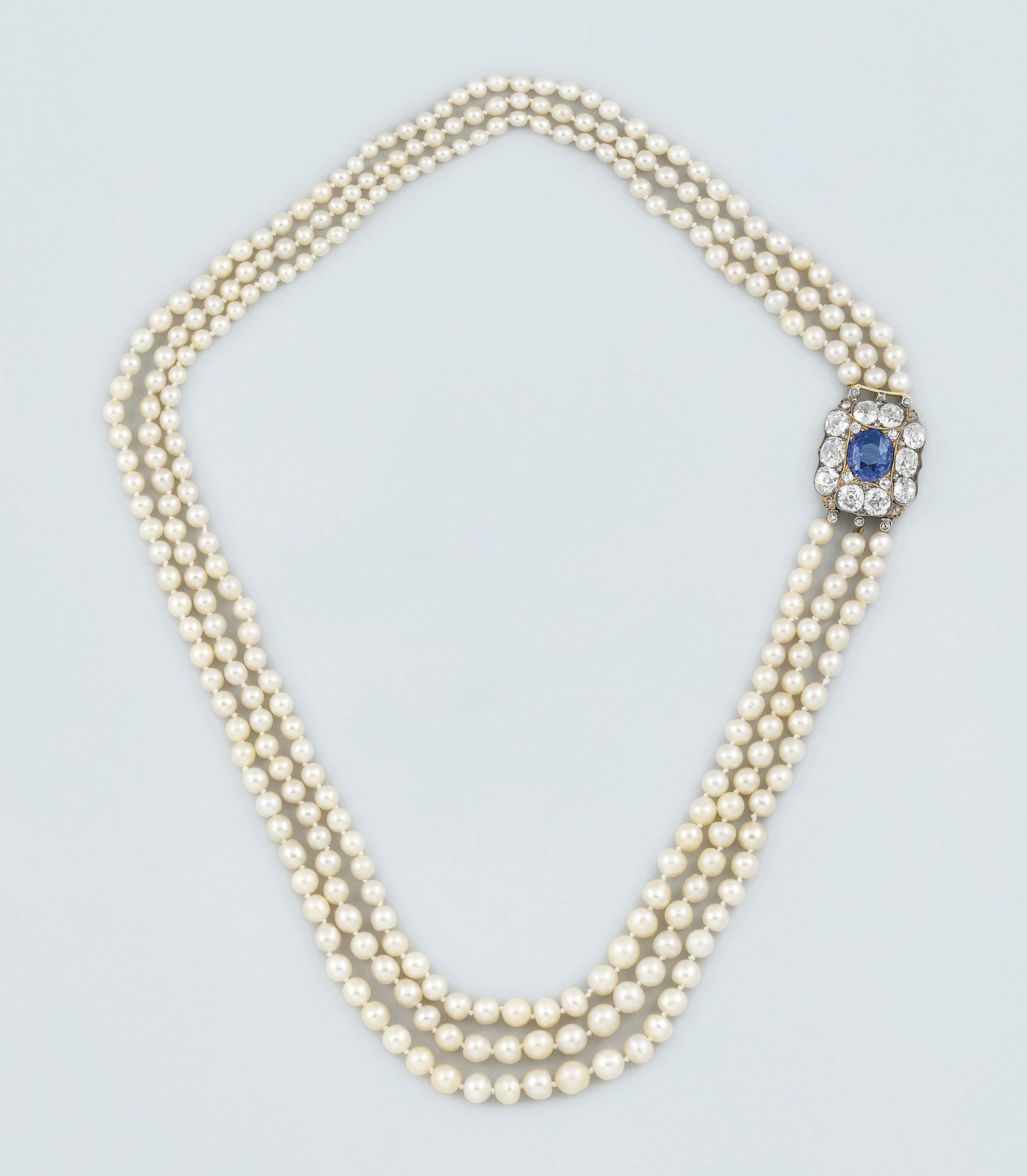A pearl necklace with diamond and sapphire clasp