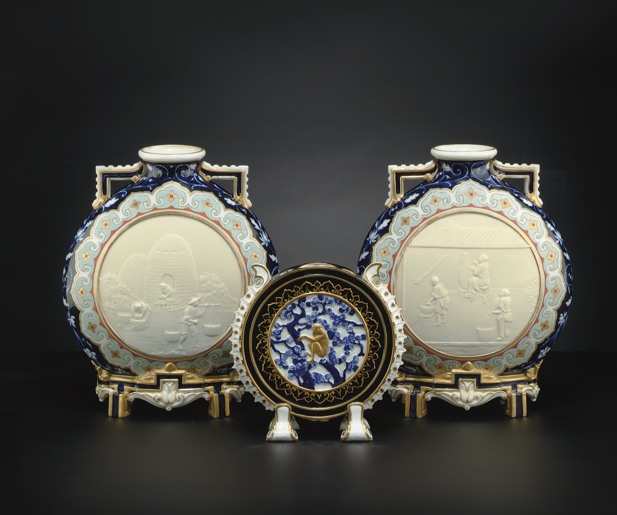 A PAIR OF ROYAL WORCESTER BLUE-GROUND PILGRIM BOTTLES AND A SIMILAR MOON-FLASK