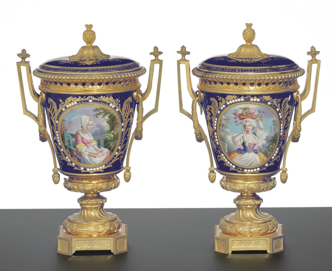 A PAIR OF ORMOLU-MOUNTED SEVRES STYLE 'JEWELED' COBALT-BLUE GROUND POT-POURRI VASES AND COVERS